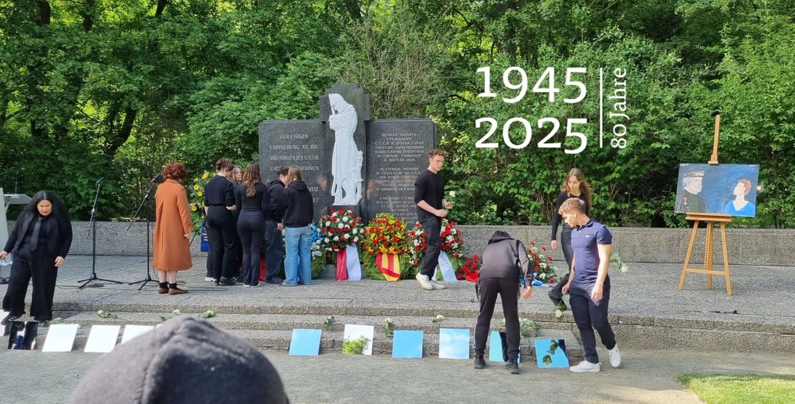 Jugendliche legen vor einem Ehrenmal Spiegel nieder